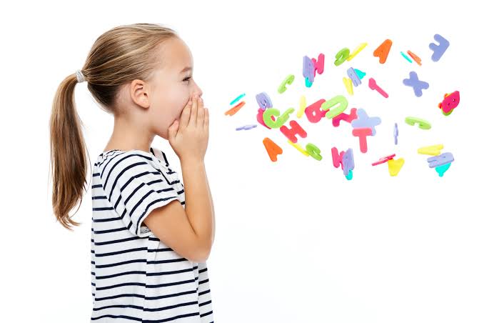 Young girl with colourful letters representing speech and communication development