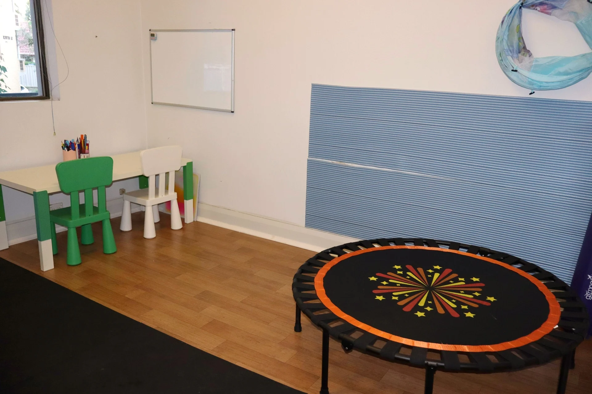 Sensory therapy room at Square One with a mini trampoline and child-height table used during occupational therapy sessions