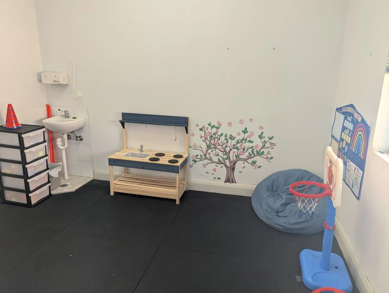 Play-based therapy room with mud kitchen and calm-down corner
